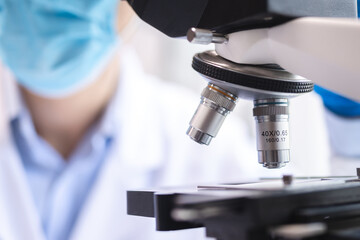 Scientist analyzing microscope slide at laboratory. Young woman technician is examining a...