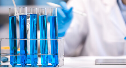 blue chemical liquid experiment in scientific glassware equipment in science medicine laboratory, chemistry or biology research discovery by using glass of test tube or beaker and flask