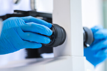 professional research scientist using microscope in science chemistry laboratory, medical technology for biology or microbiology medicine discovery, scientific equipment for experiment in hospital lab