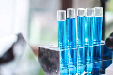 blue chemical liquid experiment in scientific glassware equipment in science medicine laboratory, chemistry or biology research discovery by using glass of test tube or beaker and flask