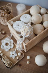 Fototapeta na wymiar Macrame decor in a wooden box, Christmas ball and stars, handmade, hobby materials.
