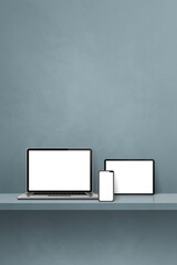 Laptop, mobile phone and digital tablet pc on grey wall shelf. Vertical background