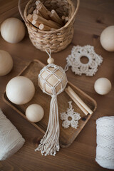 Fototapeta na wymiar Macrame decor in a wooden box, Christmas ball and stars, handmade, hobby materials.