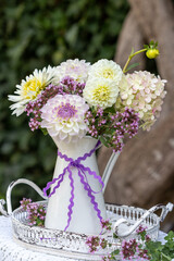 Blumenstrauß mit lila und weißen Dahlien. Hortensien-Blüten und Feldthymian im vintage Krug