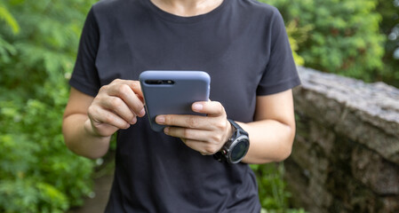 Hands using mobile phone  in summer forest