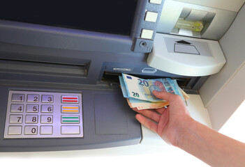 money from cash machine and numeric keypad to enter PIN code