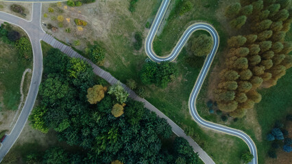 Winding bike path in the city park. City park at dawn. Aerial photography.