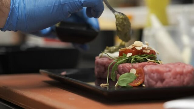 Preparation of meat tartare by a professional chaf in an Italian restaurant kitchen