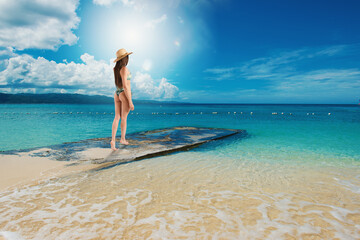 Woman relaxing under the sun at the crystalline sea