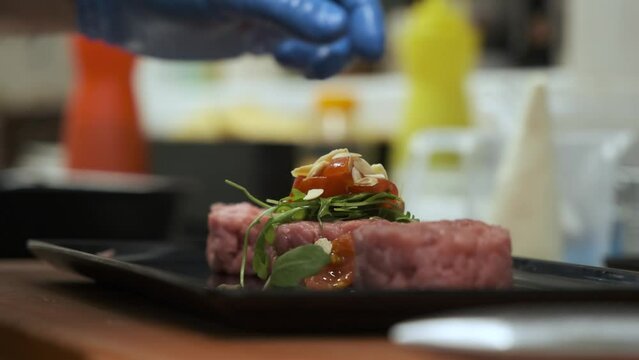 Preparation of meat tartare by a professional chaf in an Italian restaurant kitchen