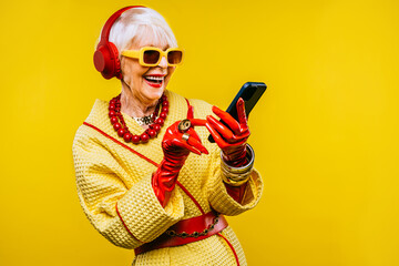 Cool and stylish senior old woman with fashionable clothes - Colorful portrait of funny happy elderly lady on colored background - obrazy, fototapety, plakaty