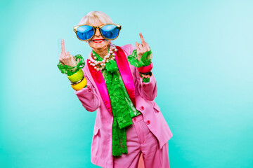 Cool and stylish senior old woman with fashionable clothes - Colorful portrait of funny happy elderly lady on colored background - obrazy, fototapety, plakaty