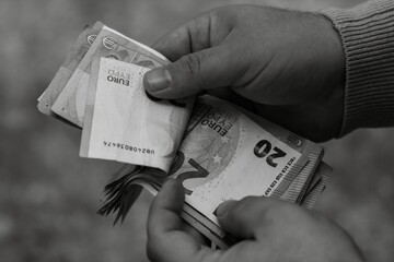 Closeup shot of euro banknotes in hand in grayscale