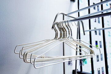 Many White clothes hangers on clothes rack at the Balcony, White clothes hangers for hang the wets clothes, laundry, clothes cleaning, housework, Store concept, empty hanger. A place for text.