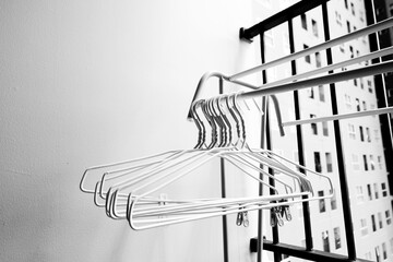 Many White clothes hangers on clothes rack at the Balcony, White clothes hangers for hang the wets clothes, laundry, clothes cleaning, housework, Store concept, empty hanger. A place for text.