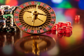 Casino. Roulette wheel, dice and poker chips on the bokeh background.