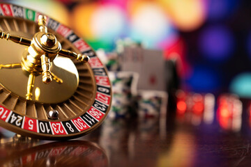 Casino. Roulette wheel, dice and poker chips on the bokeh background.