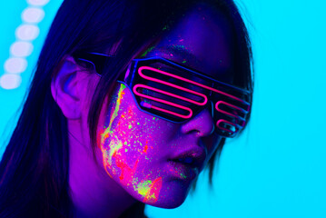 Fashion model with fluo painting on the face - Creative fashion portrait of young beautiful asian...
