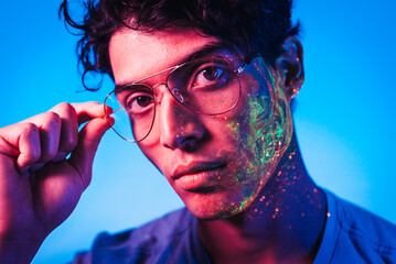 Fashion model with fluo painting on the face