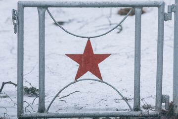 Red Soviet star on an old iron fence. Soviet symbols
