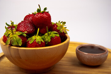 Organic red strawberries and chocolate sauce on white background.