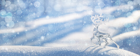 Christmas winter background, banner - view of an ice deer on a snowdrift in a winter forest,...