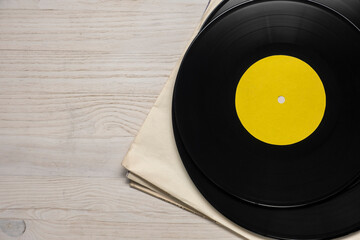 Vinyl records stack on a white wooden table