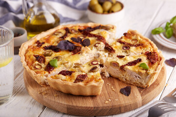 Quiche open tart pie with chicken meat, green olives and sundried tomatoes. Savory taste. Italian cuisine.