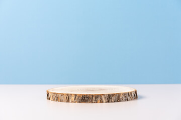 Wood podium saw cut of tree on blue background. Concept scene stage showcase, product, promotion sale, presentation, beauty cosmetic. Wooden stand studio empty. Minimal composition