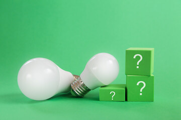 Light bulb, question mark on green background. Concept of competition for green energy market
