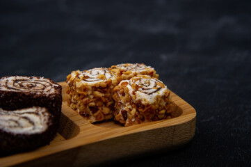 Turkish delight on wooden plate on black background
