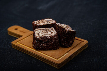 Turkish delight on wooden plate on black background