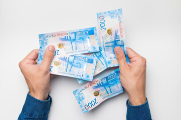 men's hand holds money in rubles on a white background, office worker