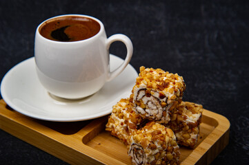 Turkish Delight and Turkish coffee in wooden plate on black background