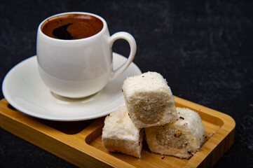Turkish Delight and Turkish coffee in wooden plate on black background