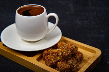 Turkish Delight and Turkish coffee in wooden plate on black background