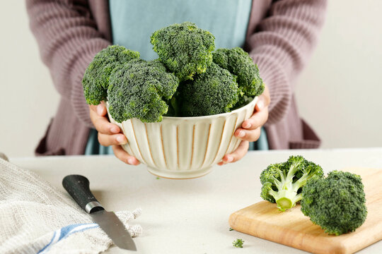 Female Hand Holding A Bowl of Broccoli