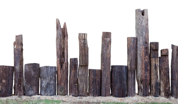 Isolation of a decayed wooden stump, which is installed as an artifical fence on the sand in the garden.