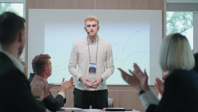 diffident and nervous man is speaking in business meeting with colleagues and partners