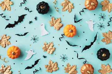 Halloween holiday background with party decorations of pumpkins, bats, ghosts, spiders on blue top...