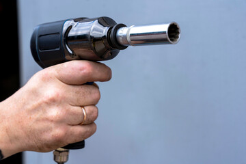 a pneumatic impact wrench with an end head in the hand of a master