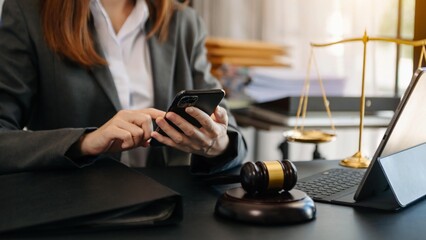 justice and law concept.Male judge in a courtroom  the gavel, working with smart phone and laptop and digital tablet computer on wood table