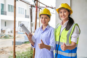 Two female in foreman uniform are trumbing up on construction site