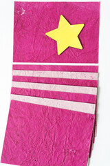 wood star painted yellow on pink paper with stripes element