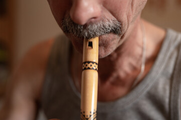 senior man playing the flute. faceless unprofessional male of elderly caucasian recorder people...