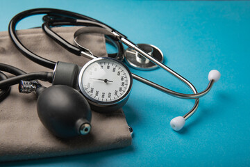Gray tonometer and heart on a blue background. Medical equipment blood pressure monitor....