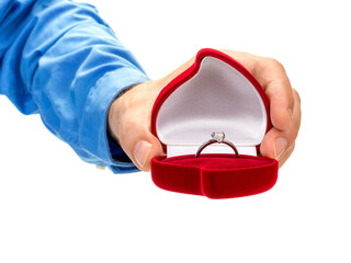 A man's hand holds a red velvet box with a diamond ring. The concept of marriage proposal, engagement. Isolated on white background.