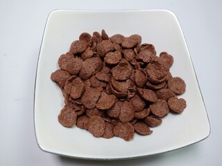 Cornflakes pile for breakfast, heap of brown choco cereals 