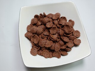 Cornflakes pile for breakfast, heap of brown choco cereals 