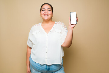 Cheerful fat young woman showing her smartphone screen and smiling